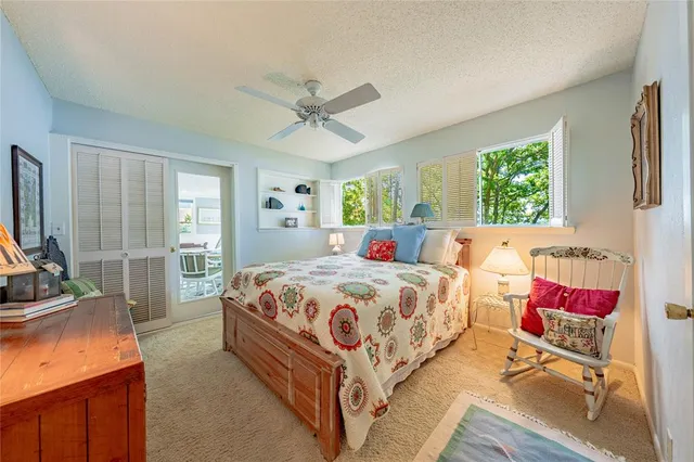 a bedroom with a bed and large windows