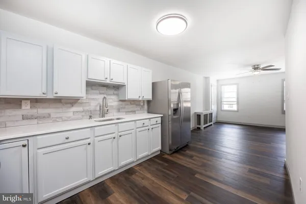 a large kitchen with lot of counter space and wooden floor