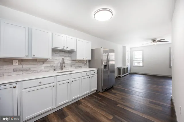 a large kitchen with lot of counter space and wooden floor