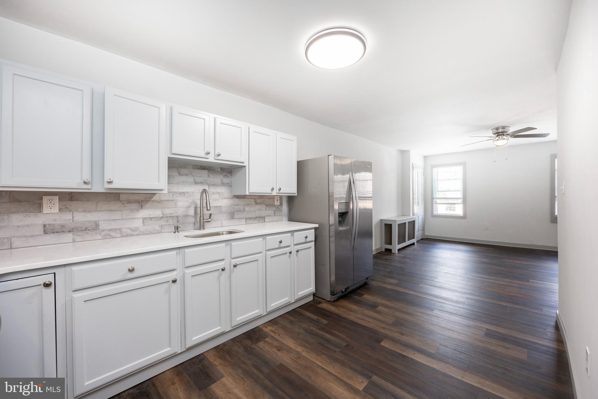 a large kitchen with lot of counter space and wooden floor