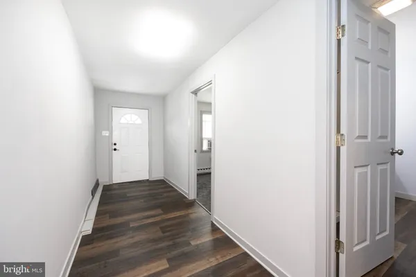 a view of a hallway with wooden floor and entryway