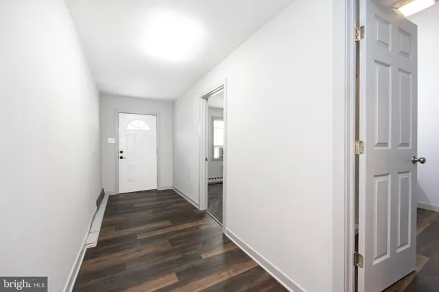 a view of a hallway with wooden floor and entryway