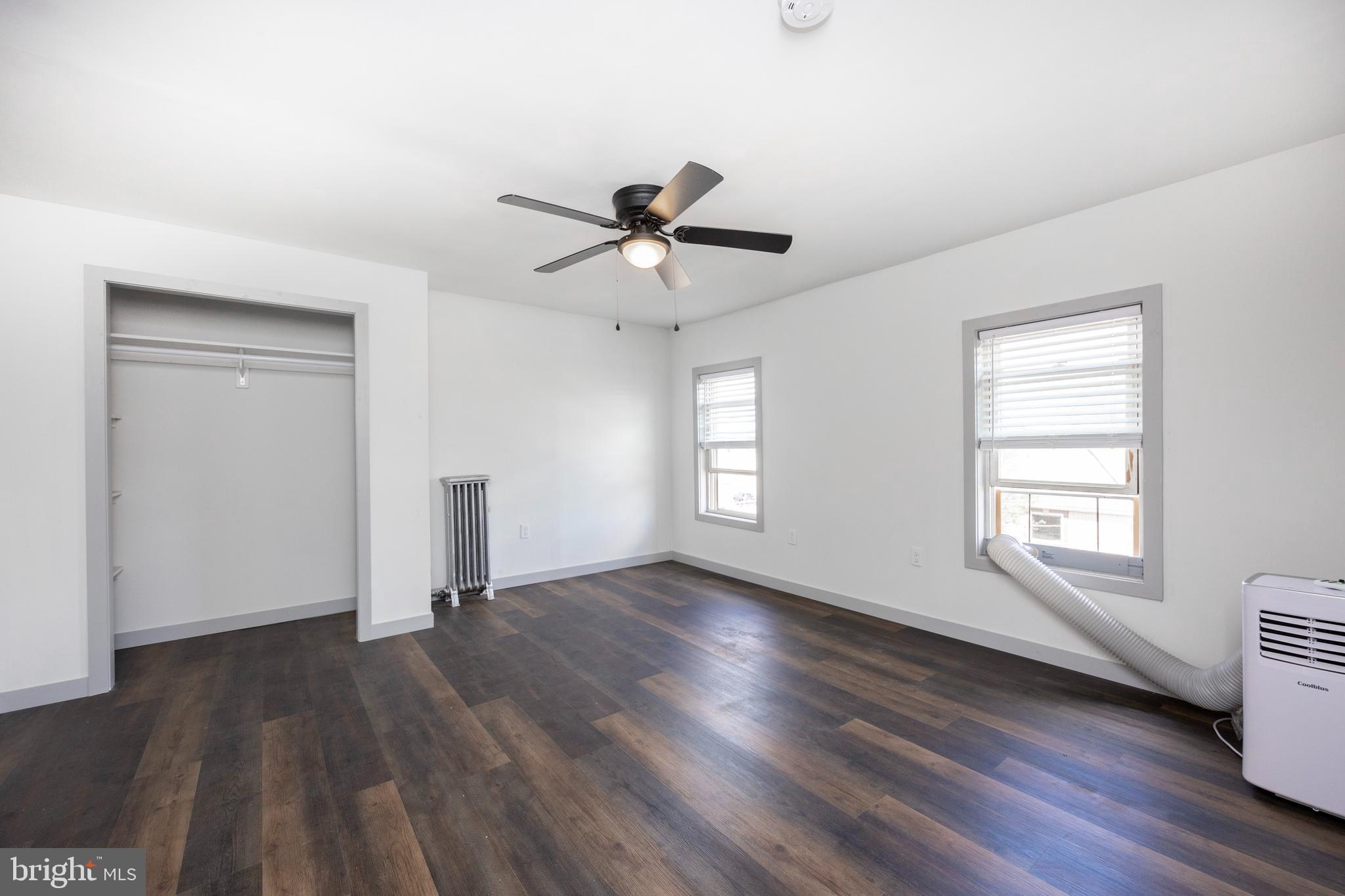 58 East 4th Street, Unit 2 Bridgeport, PA 19405 - Photo 17 of 28 an empty room with wooden floor chandelier fan and windows