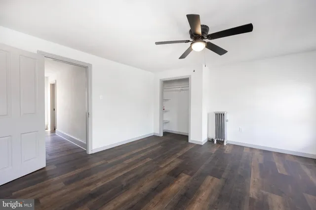 a view of empty room with wooden floor and window