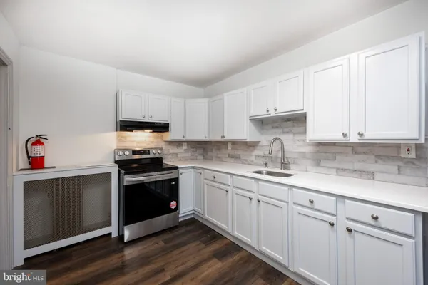 a kitchen with granite countertop white cabinets and white appliances