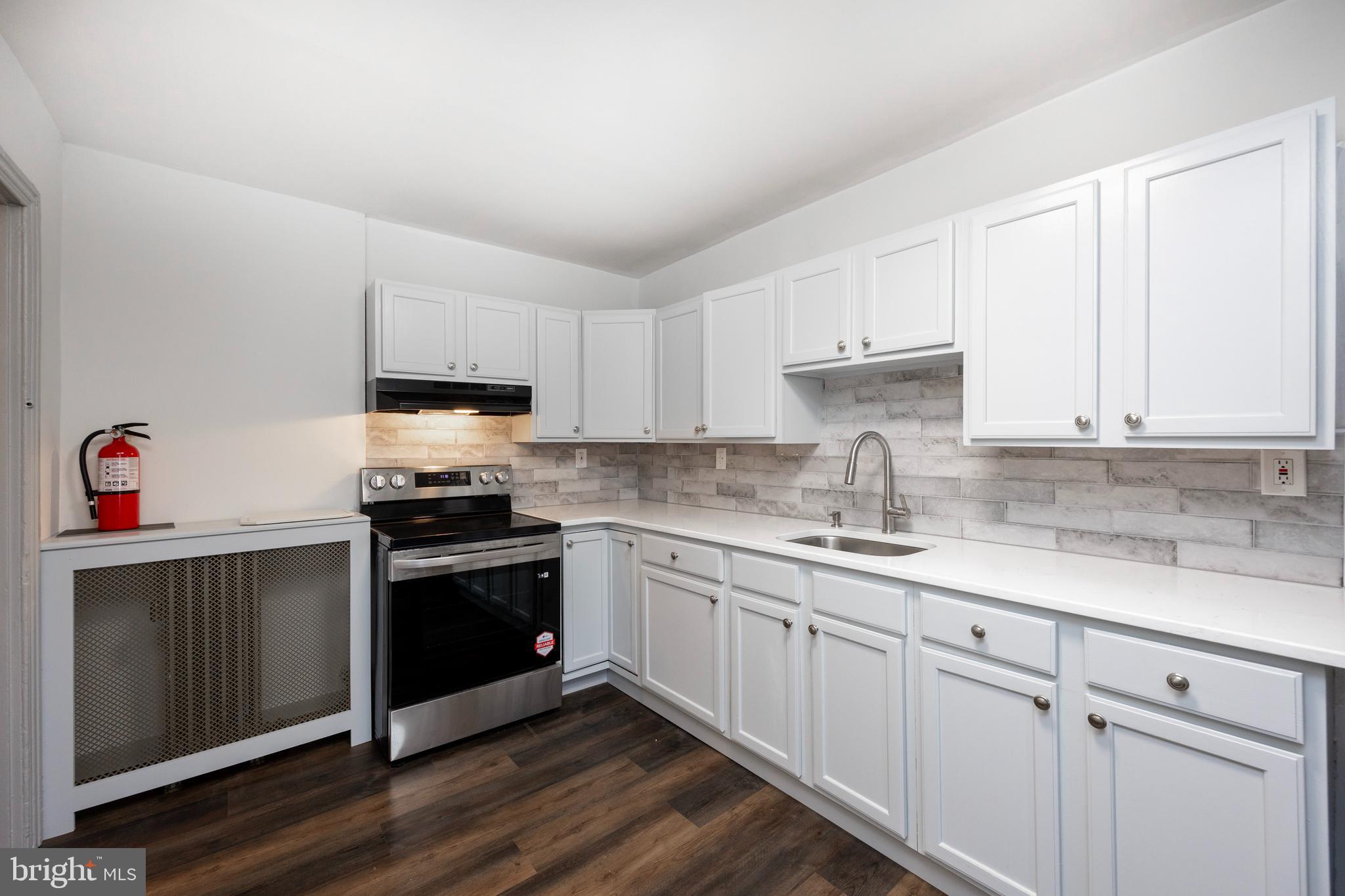 58 East 4th Street, Unit 2 Bridgeport, PA 19405 - Photo 2 of 28 a kitchen with granite countertop white cabinets and white appliances