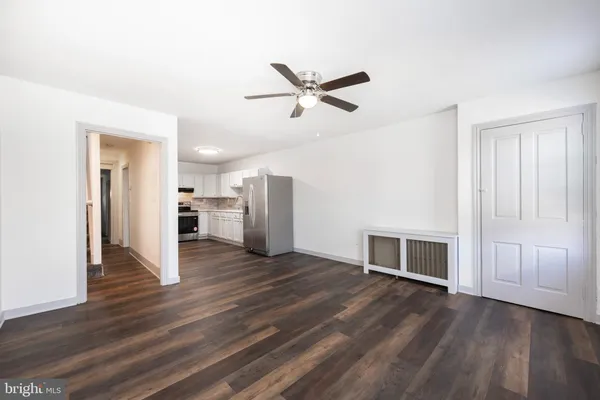 a view of a livingroom with wooden floor and a ceiling fan