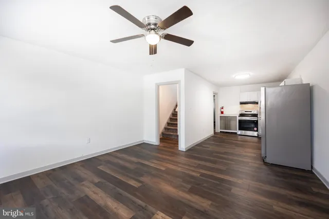 a view of a livingroom with wooden floor and a ceiling fan