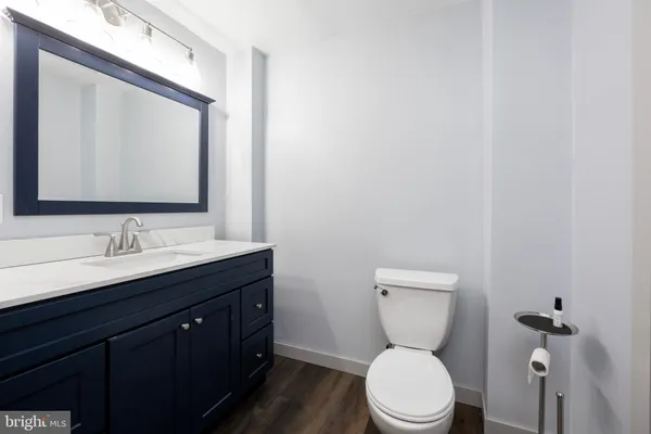 a bathroom with a toilet a sink a mirror and vanity