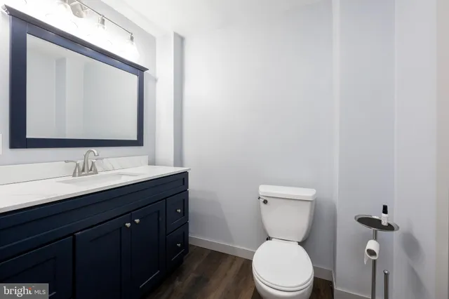 a bathroom with a toilet a sink a mirror and vanity