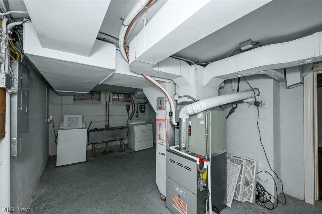 3699 Bainbridge Road Cleveland Heights, OH 44118 - Photo 35 of 37 Basement utility area featuring a forced air furnace, exposed ductwork, a laundry sink, and a washer and dryer