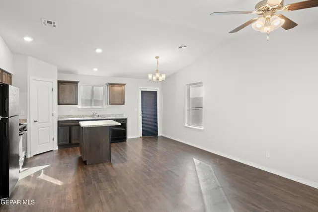 a kitchen with kitchen island white cabinets and stainless steel appliances