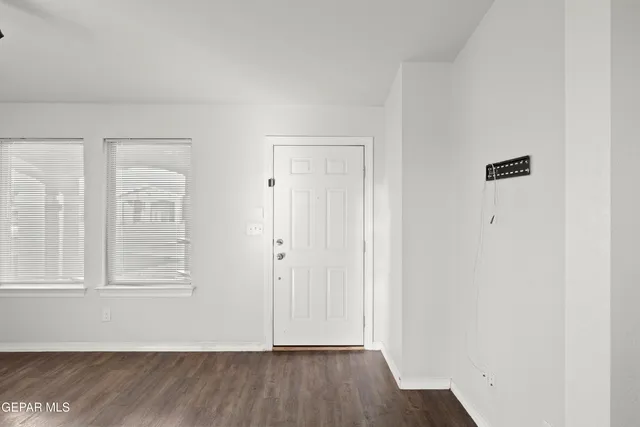 a view of an empty room with wooden floor and closet