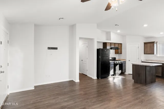 a view of a kitchen with stainless steel appliances wooden floor and chair