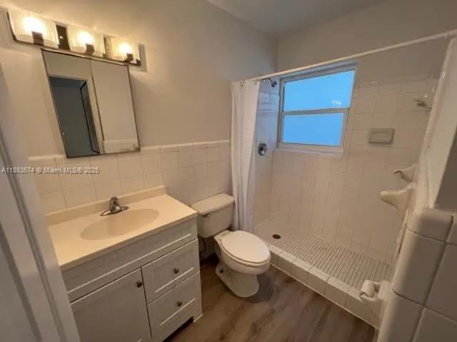 a bathroom with a sink a toilet a mirror and shower