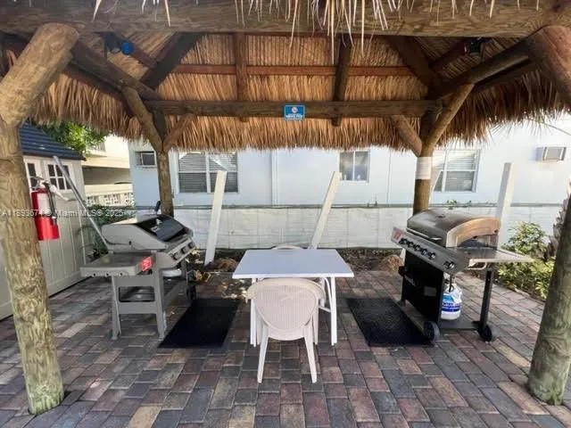 a view of the patio with dining table and chairs under an umbrellas