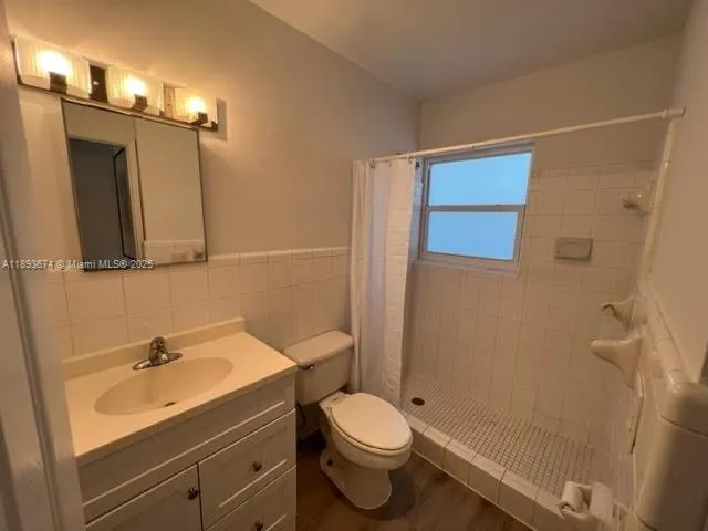 a bathroom with a sink a toilet a mirror and shower