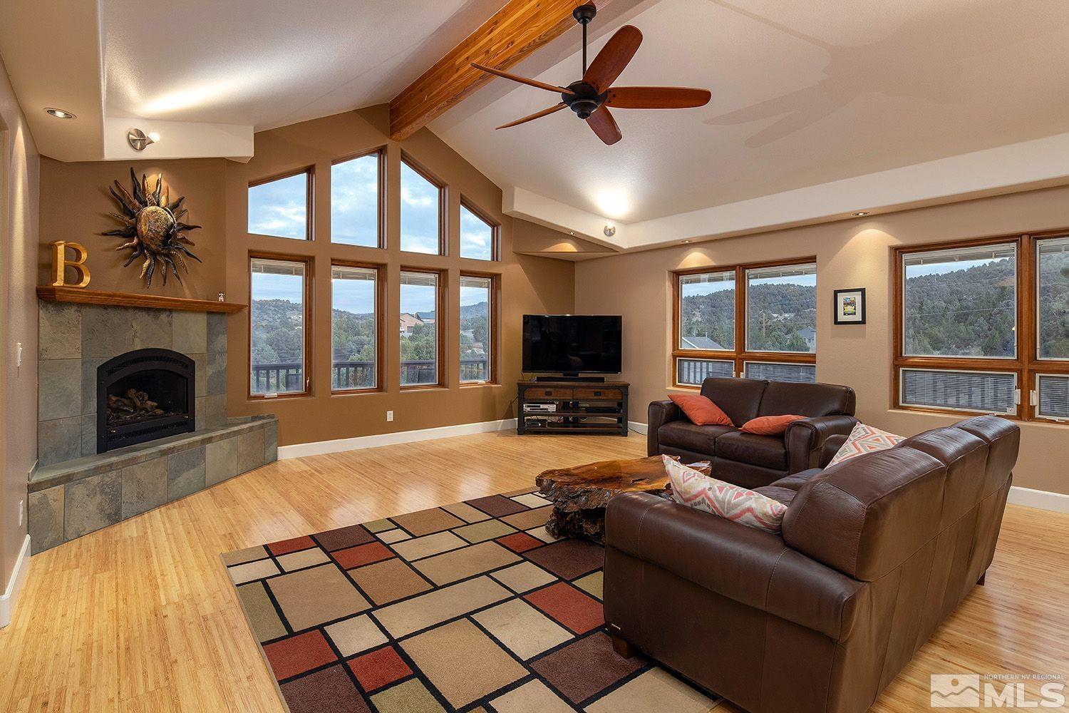 22010 Panhandle Road Reno, NV 89521 - Photo 4 of 32 a living room with furniture a flat screen tv and a fireplace