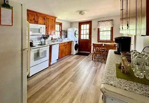 a kitchen with stainless steel appliances granite countertop wooden floors a stove and a refrigerator
