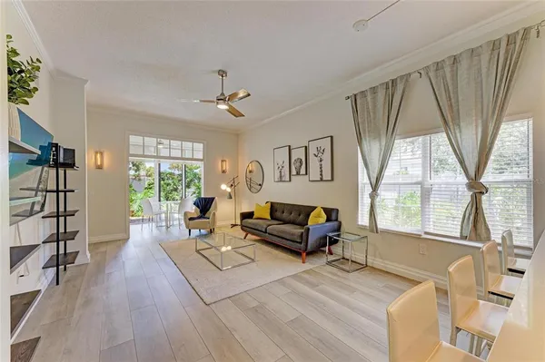 a living room with furniture wooden floor and a large window