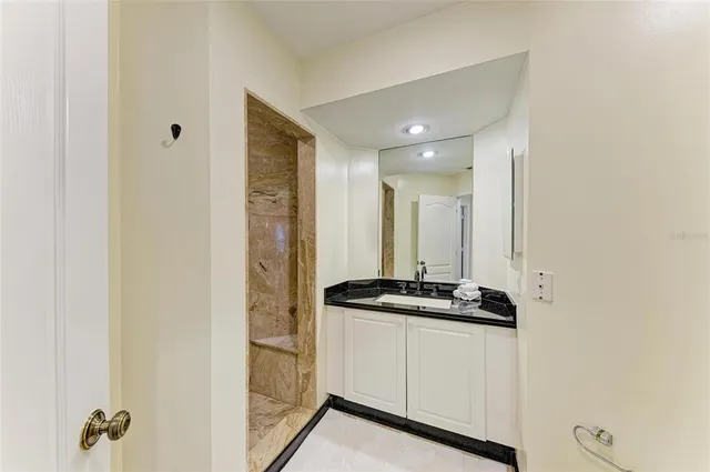 a bathroom with a granite countertop sink and a mirror
