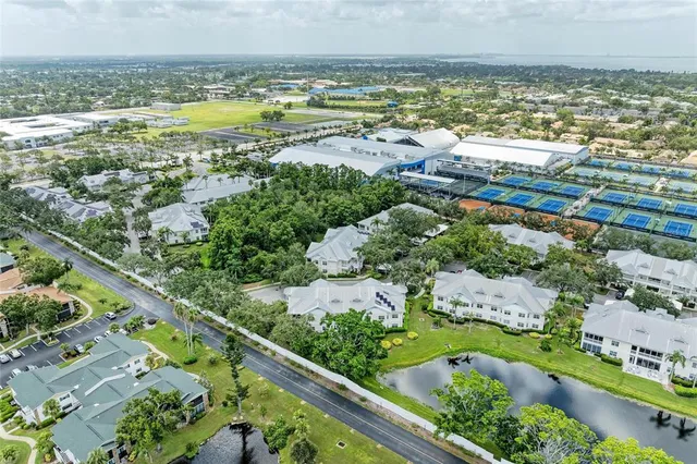 an aerial view of a city with lots of residential buildings ocean and mountain view in back