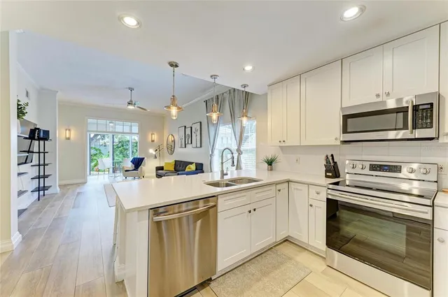 a dining room with stainless steel appliances kitchen island granite countertop a table and chairs