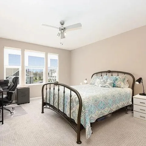 a spacious bedroom with a bed and a window