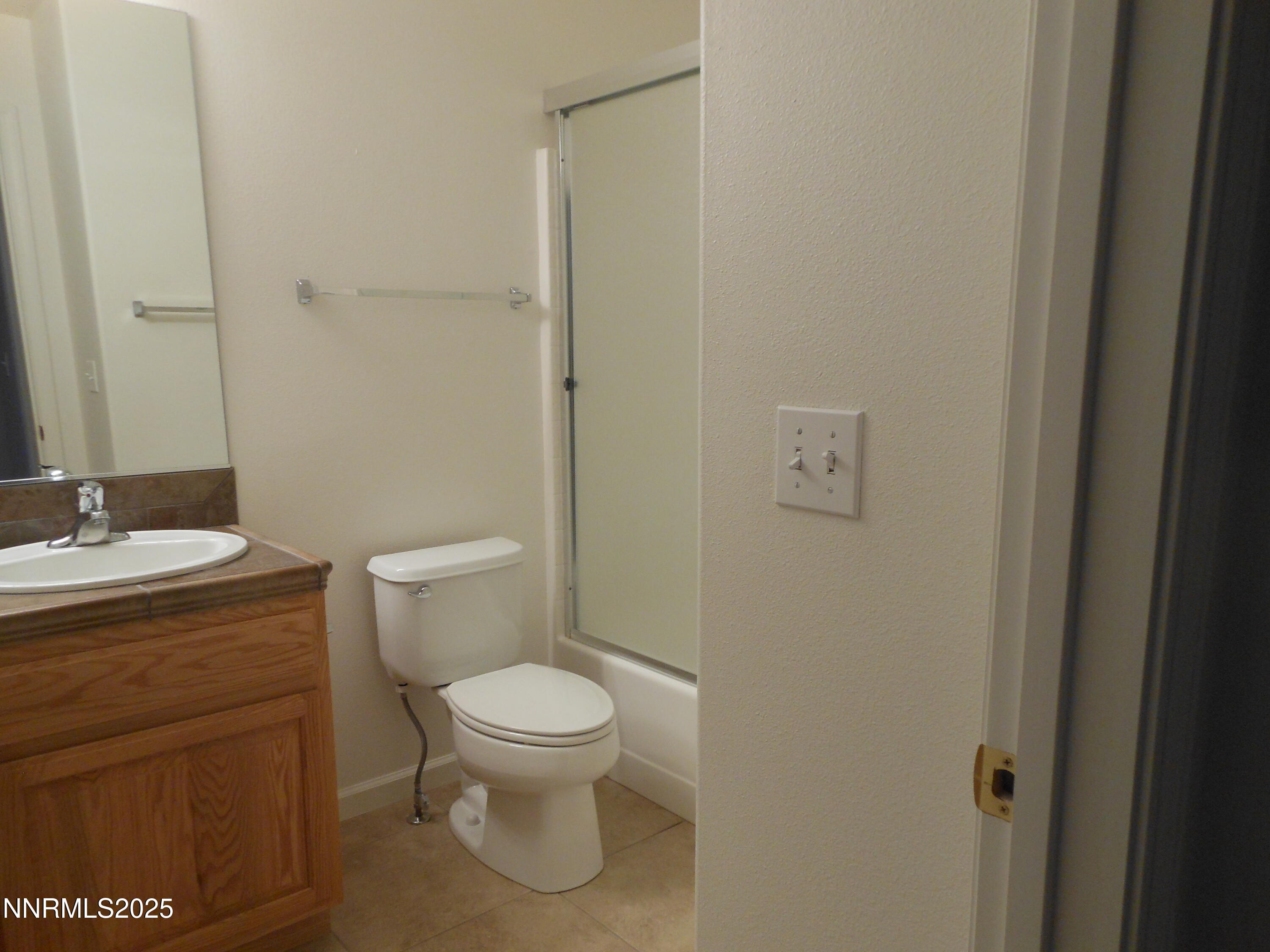 655 Desert Springs Court Fallon, NV 89406 - Photo 12 of 16 a bathroom with a granite countertop toilet a sink and a mirror
