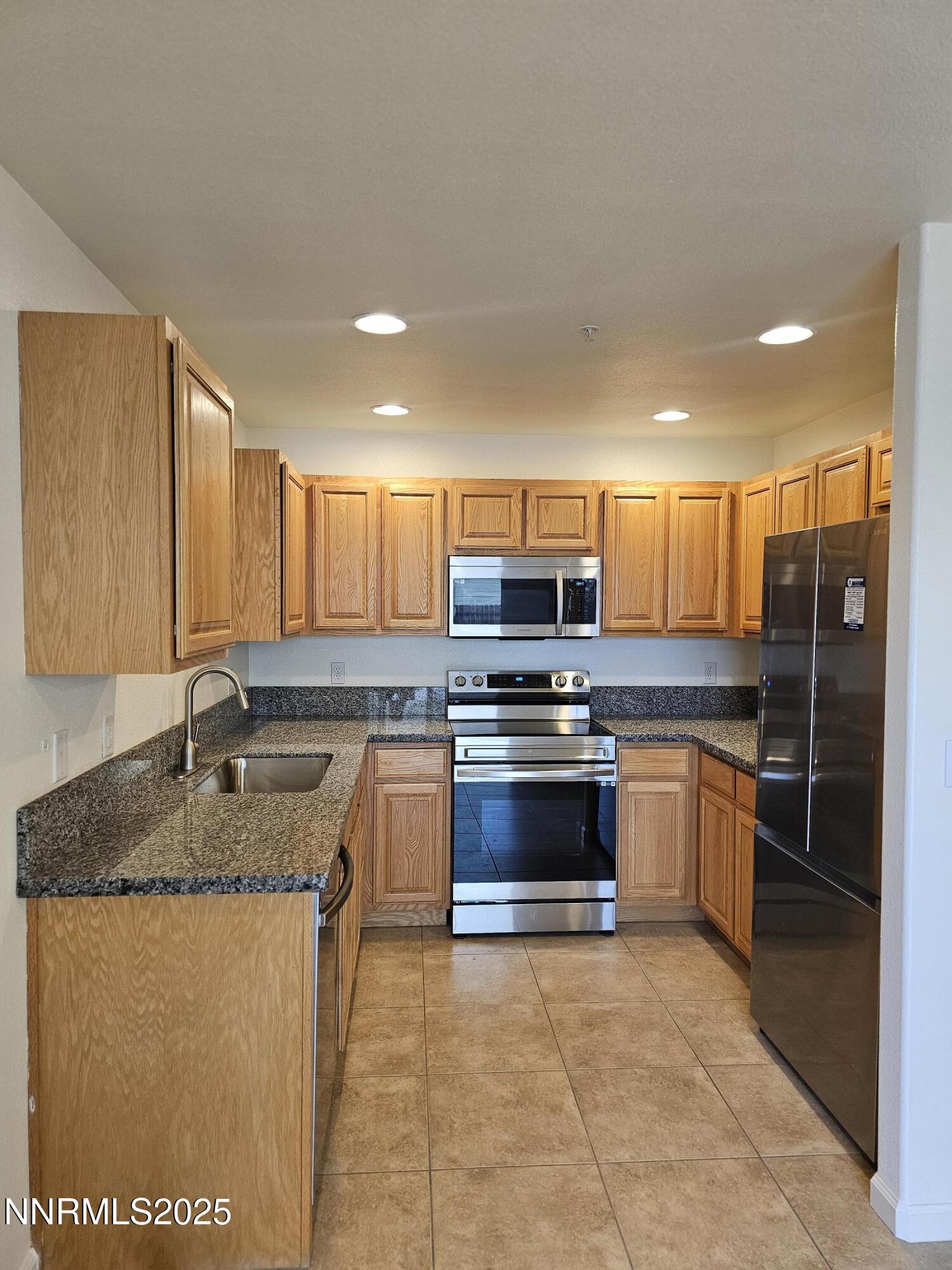 655 Desert Springs Court Fallon, NV 89406 - Photo 2 of 16 a kitchen with stainless steel appliances granite countertop a stove a sink and a refrigerator