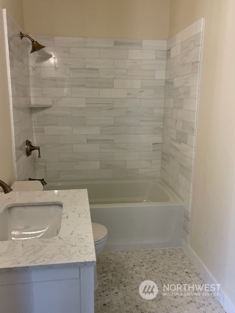 720 Guard Street, Unit 4 Friday Harbor, WA 98250 - Photo 15 of 19 a bathroom with a granite countertop sink a toilet and bathtub