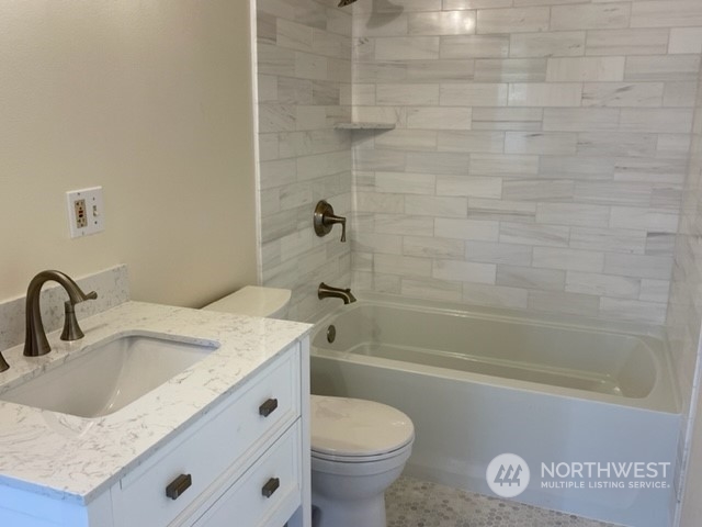 720 Guard Street, Unit 4 Friday Harbor, WA 98250 - Photo 16 of 19 a bathroom with a granite countertop sink a toilet and shower