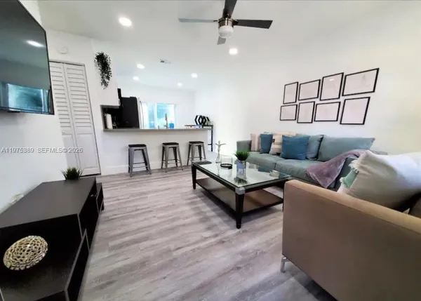 a living room with furniture and a wooden floor
