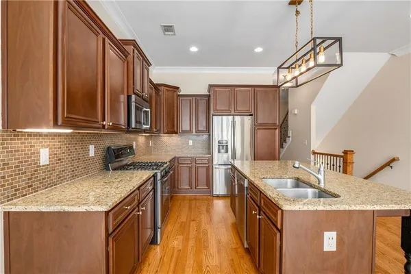 a kitchen that has a sink a stove and a wooden floor