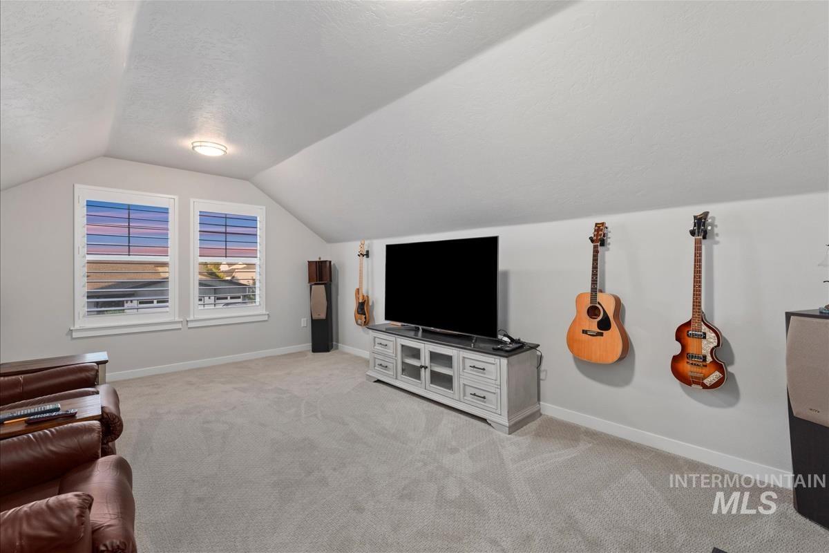 15451 Lutsen Avenue Caldwell, ID 83607 - Photo 33 of 39 Spacious bonus room featuring an angled ceiling, two windows with white plantation shutters, neutral carpeting, and recessed lighting
