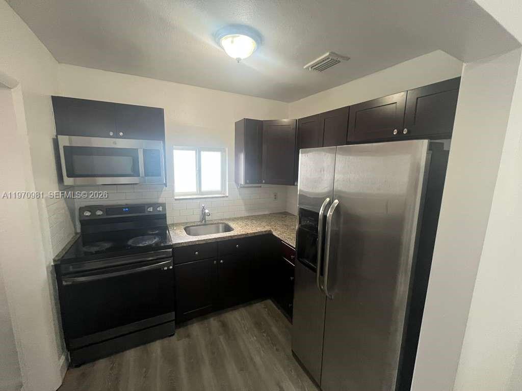 2758 Southwest 3rd Street Miami, FL 33135 - Photo 13 of 19 a kitchen with granite countertop a refrigerator and a sink