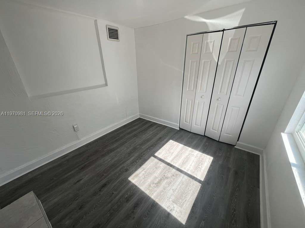 2758 Southwest 3rd Street Miami, FL 33135 - Photo 16 of 19 a view of an empty room with wooden floor and a window