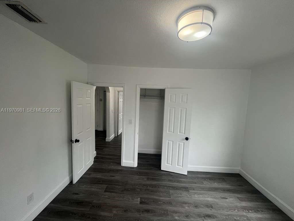2758 Southwest 3rd Street Miami, FL 33135 - Photo 6 of 19 an empty room with wooden floor and mirror