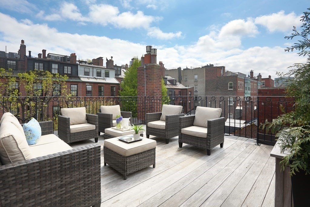 44 Cedar Ln Way Boston, MA 02114 - Photo 13 of 17 a view of a roof deck with couches and potted plants