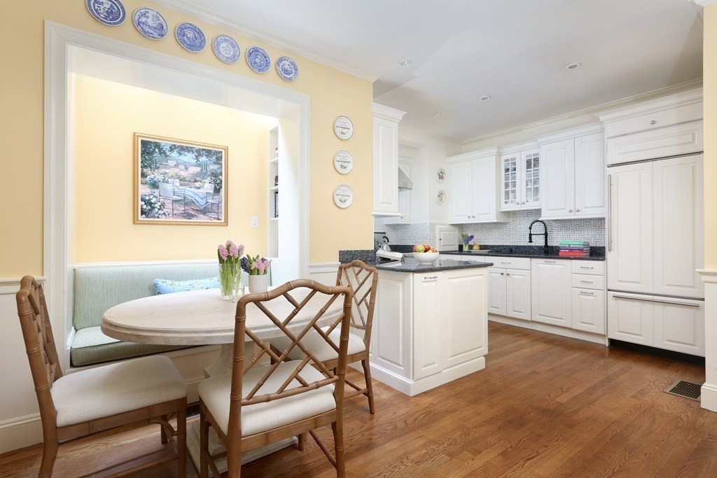 44 Cedar Ln Way Boston, MA 02114 - Photo 3 of 17 a kitchen with a table chairs a sink dishwasher and cabinets with wooden floor
