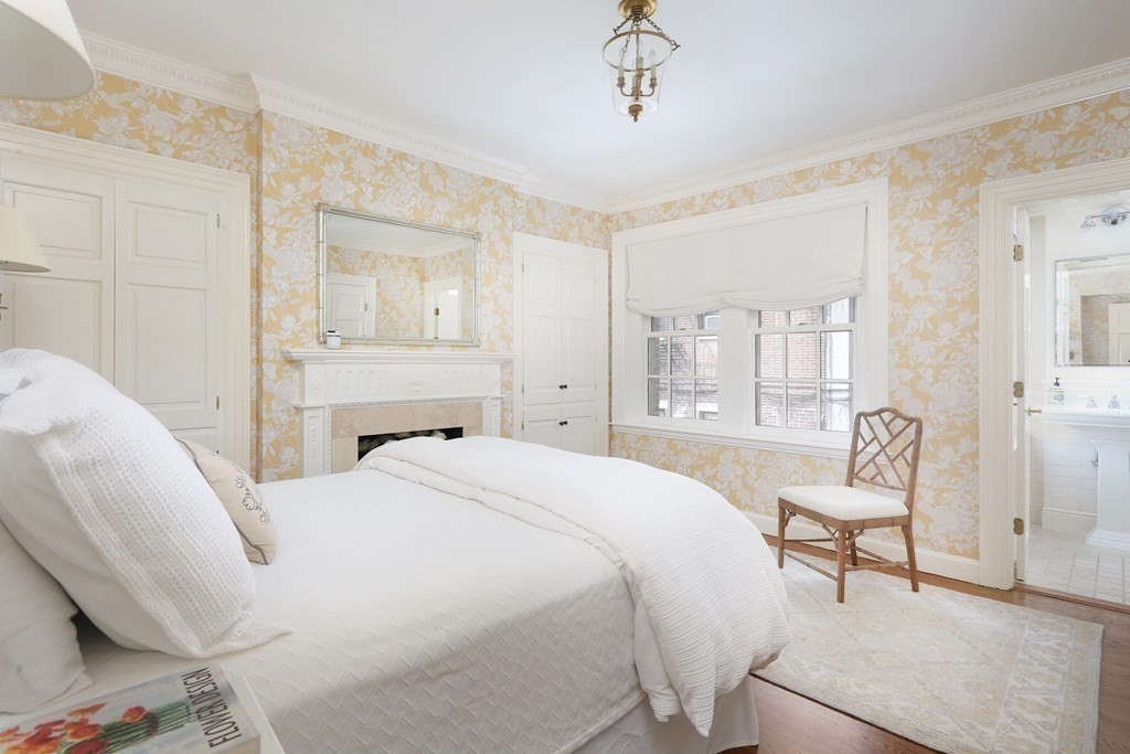 44 Cedar Ln Way Boston, MA 02114 - Photo 8 of 17 a spacious bedroom with a bed and a chandelier