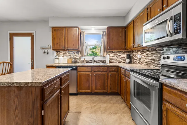 a kitchen with stainless steel appliances granite countertop a sink stove and cabinets