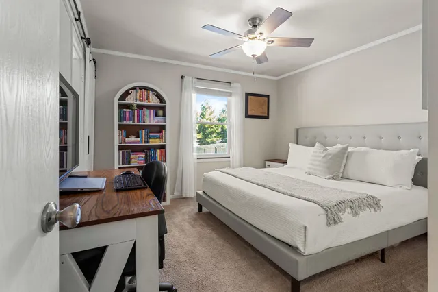a bedroom with bed and a book shelf