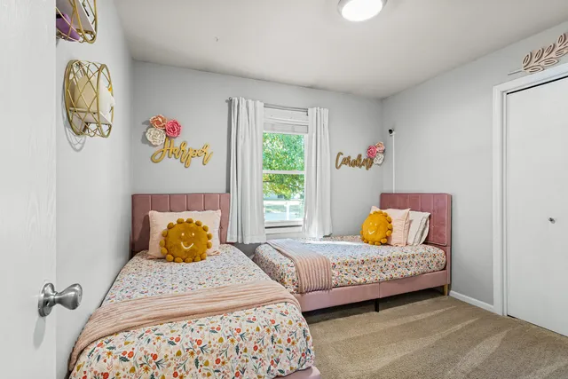 a bedroom with a bed and painting on the wall