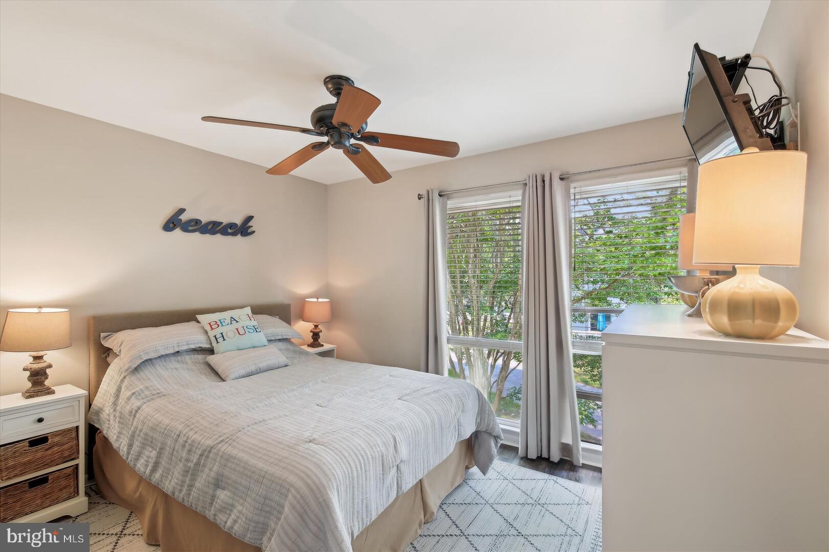 39689 Round Robin Way, Unit 3103 Bethany Beach, DE 19930 - Photo 17 of 34 a bedroom with a bed a window and a chandelier