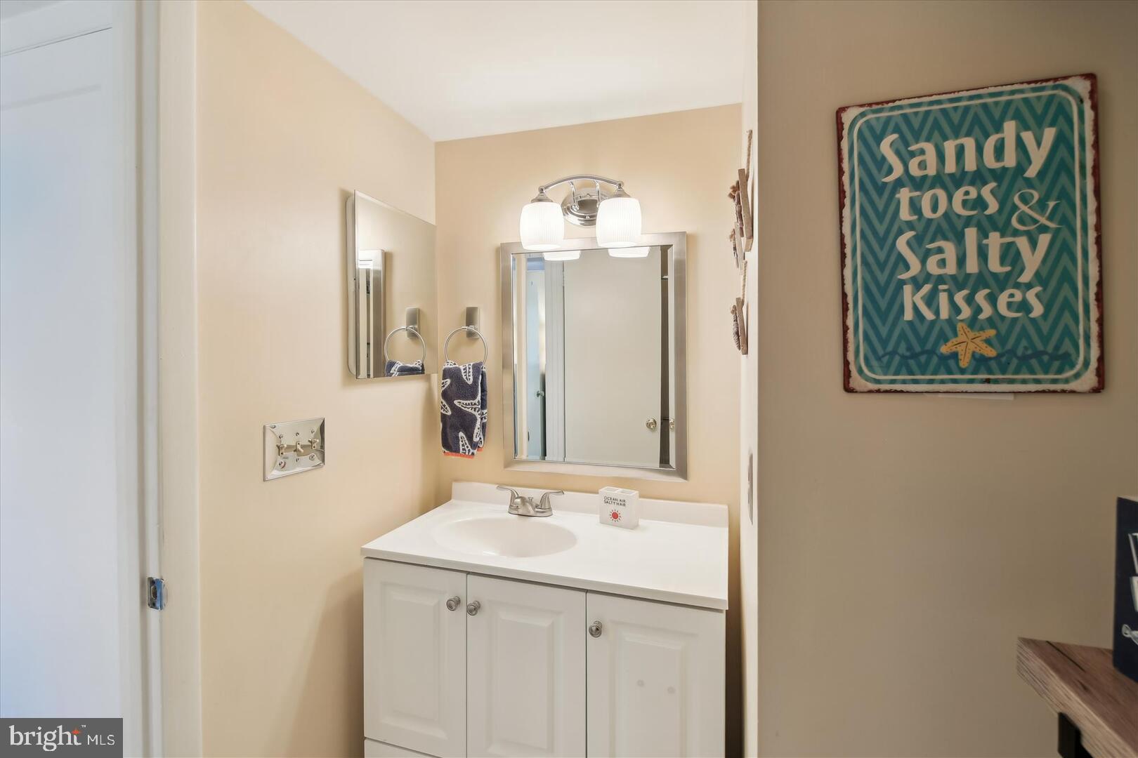 39689 Round Robin Way, Unit 3103 Bethany Beach, DE 19930 - Photo 20 of 34 a bathroom with a sink and a mirror