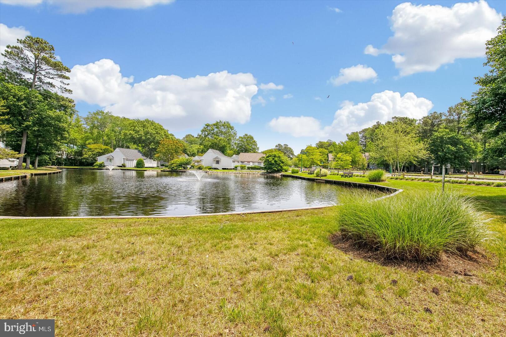 39689 Round Robin Way, Unit 3103 Bethany Beach, DE 19930 - Photo 24 of 34 a view of a lake with houses in the background