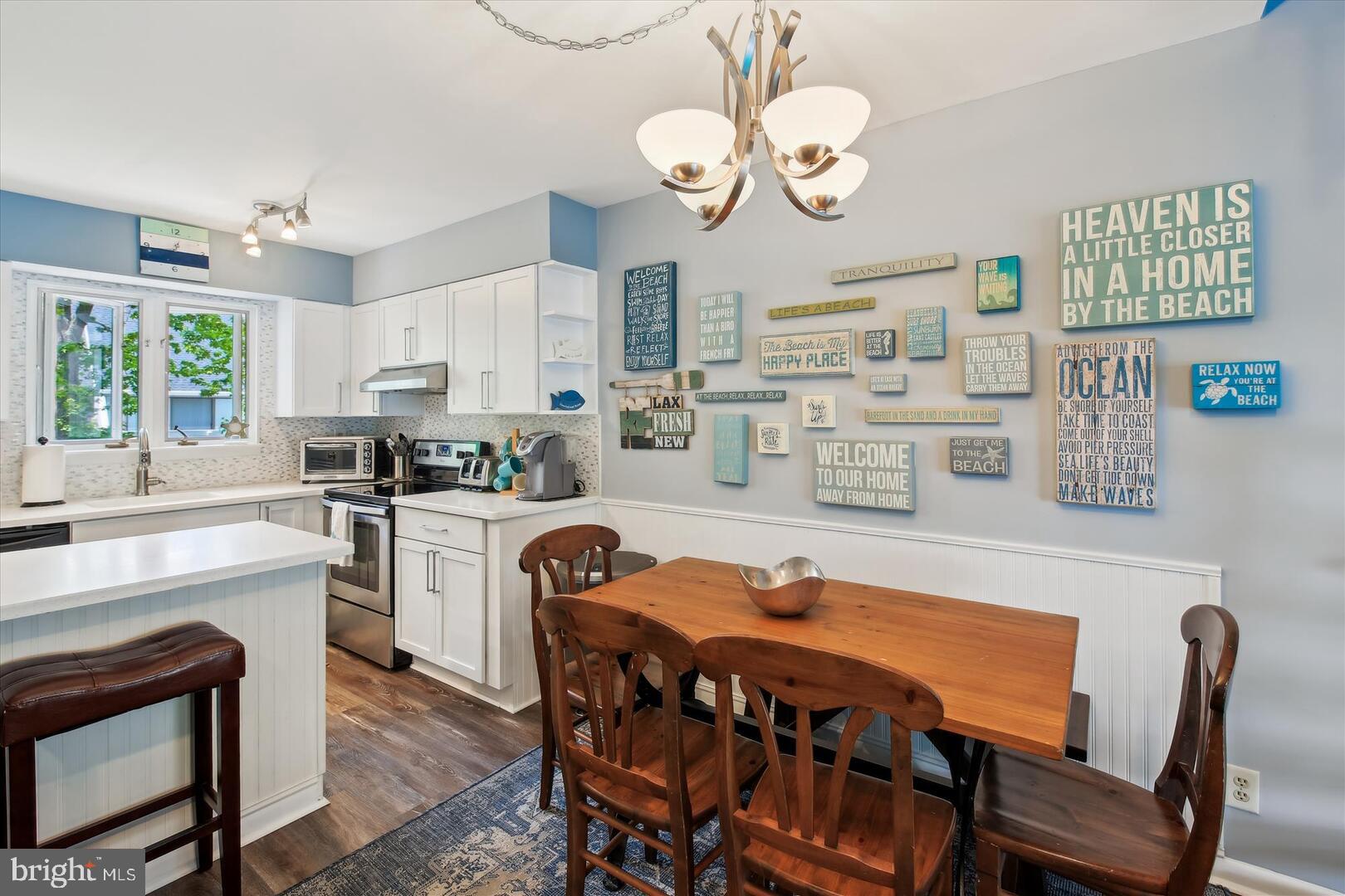 39689 Round Robin Way, Unit 3103 Bethany Beach, DE 19930 - Photo 5 of 34 a kitchen with stainless steel appliances granite countertop a stove a sink dishwasher a dining table and chairs with wooden floor