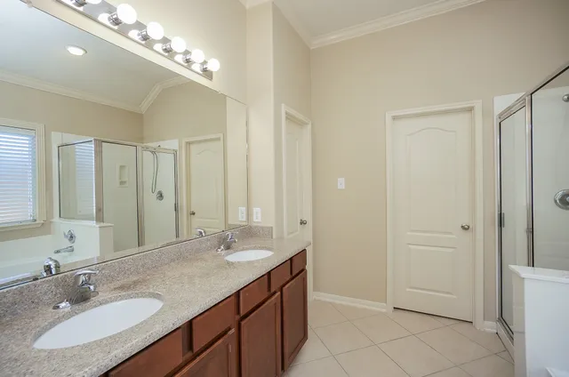 a bathroom with a granite countertop sink a large mirror and a shower