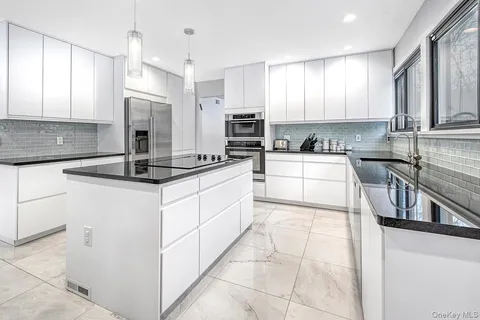 a kitchen with stainless steel appliances granite countertop a sink stove and cabinets